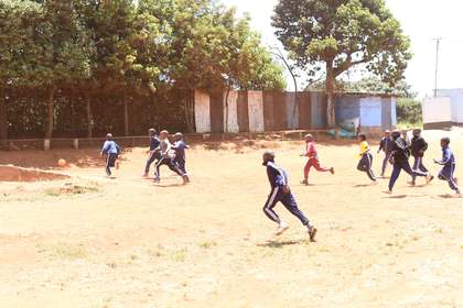 A learner mid-jump while playing on the field.