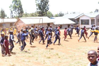 Learners running across the playing field.