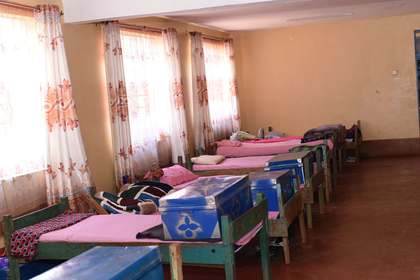 A boarding dormitory room with curtained windows.