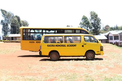 A Kagira Memorial Academy school bus parked on campus.