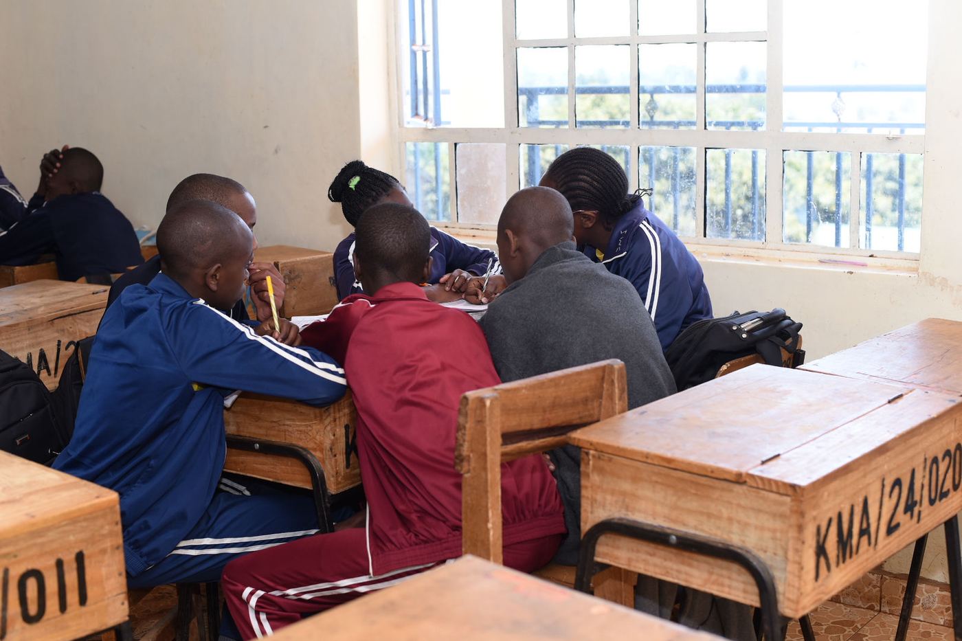 Learners working together in small groups inside their classroom at Kagira Memorial Academy.