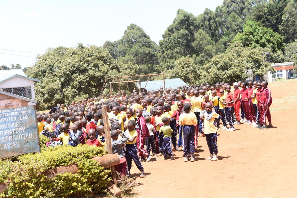 Learners and staff at the school's flag area during an assembly.
